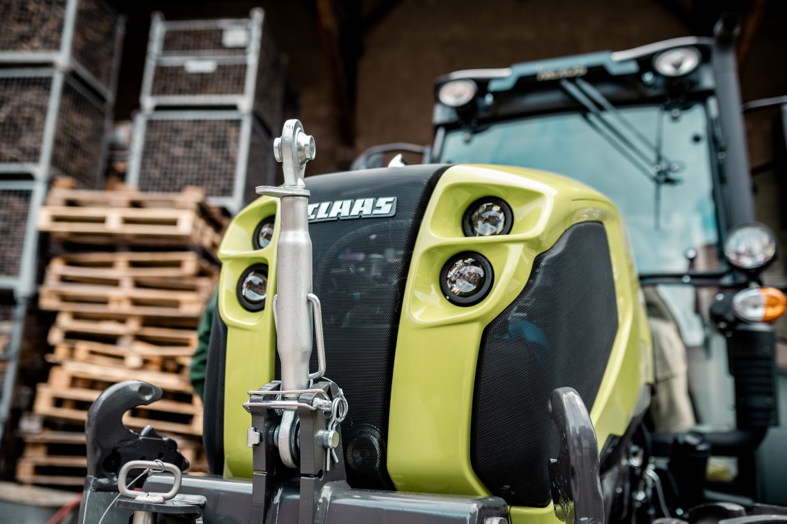 CLAAS Nexos Weinbergtraktor vor leeren Paletten