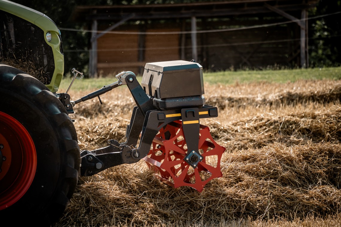 Traktor mit Schwadniederhalter bei der Strohernte